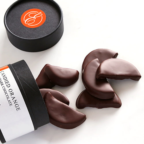Dark chocolate orange segments with a branded container on a white background