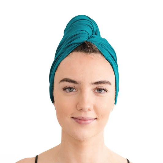 A girl with a teal cotton fabric wrapped on her head like a turban