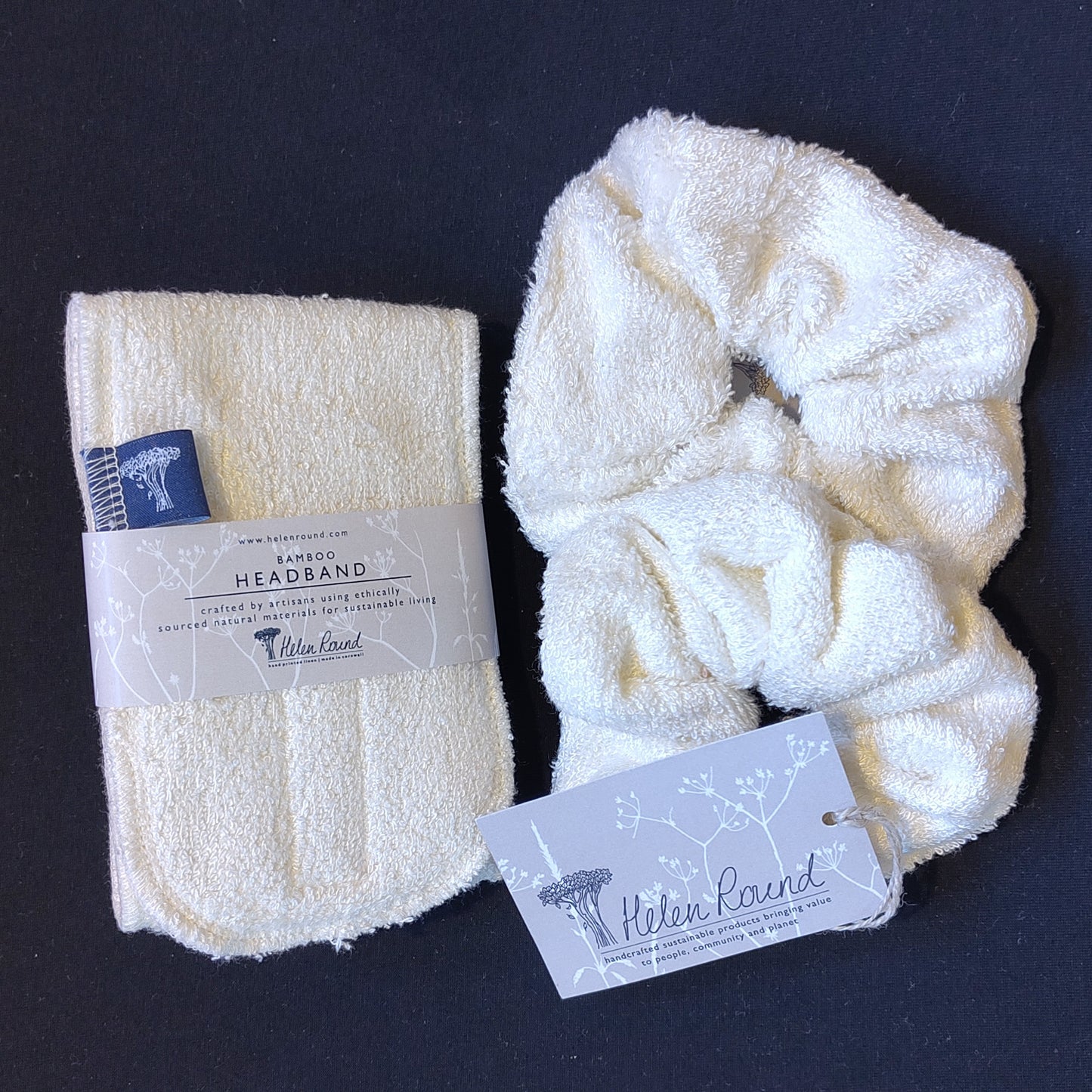 White bamboo headband and wrist wash band set with 'Helen Round' labels on a dark background