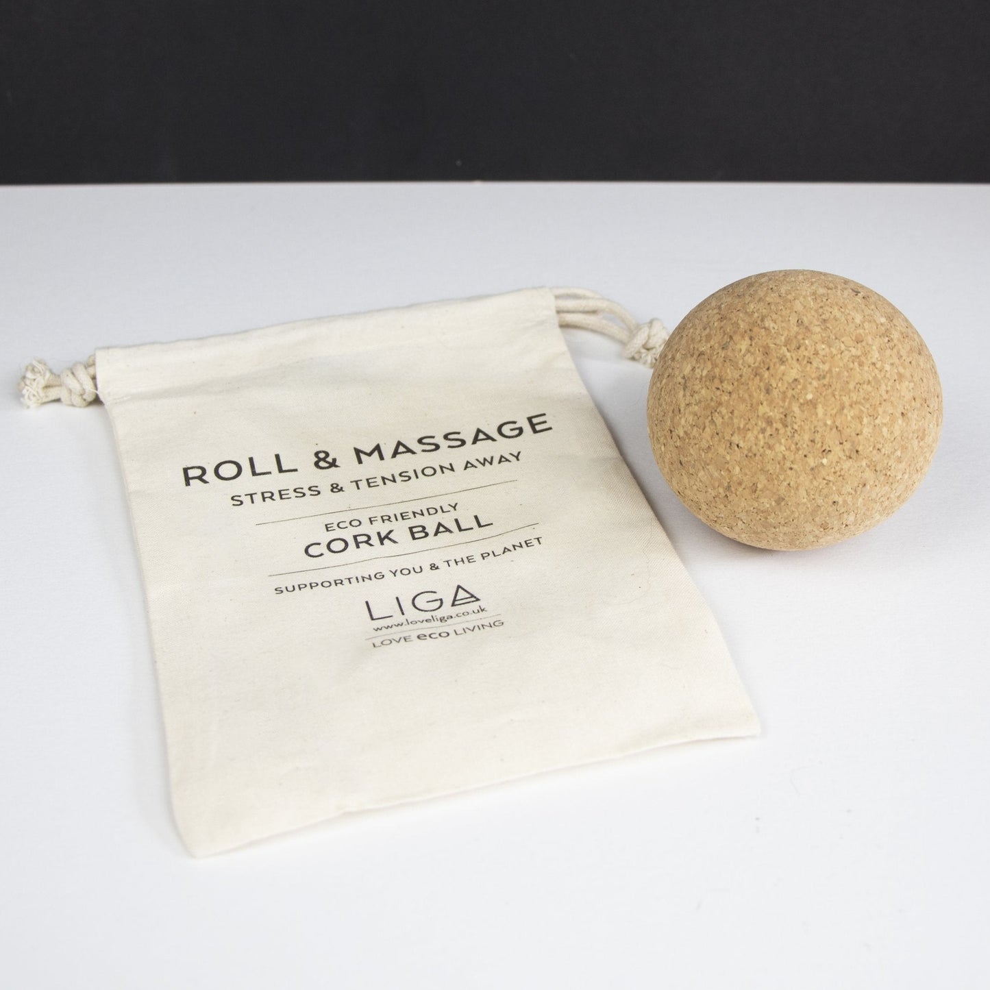 Cork massage ball (same size as a tennis ball) with a drawstring bag saying 'Roll and Massage'