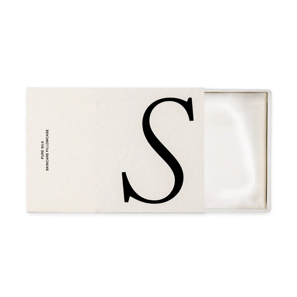 Rectangular white cardboard box with a large 'S' on it, open to show a folded white silk pillowcase inside