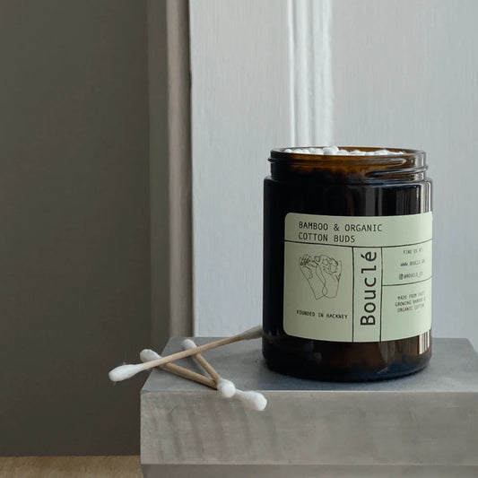 Boucle bamboo and organic cotton buds jar on a gray surface with a neutral background