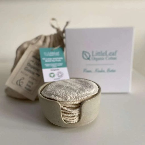 Set of reusable cotton pads in a ceramic pot with a branded box in the background.