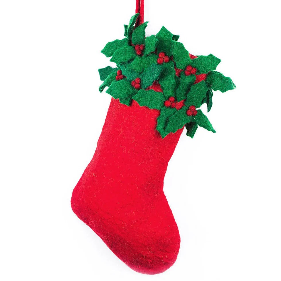 Red Christmas stocking with green holly leaves and red berries on a white background