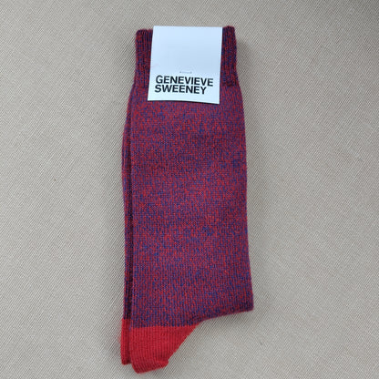 A folded pair of wool socks with a label saying Genevieve Sweeney