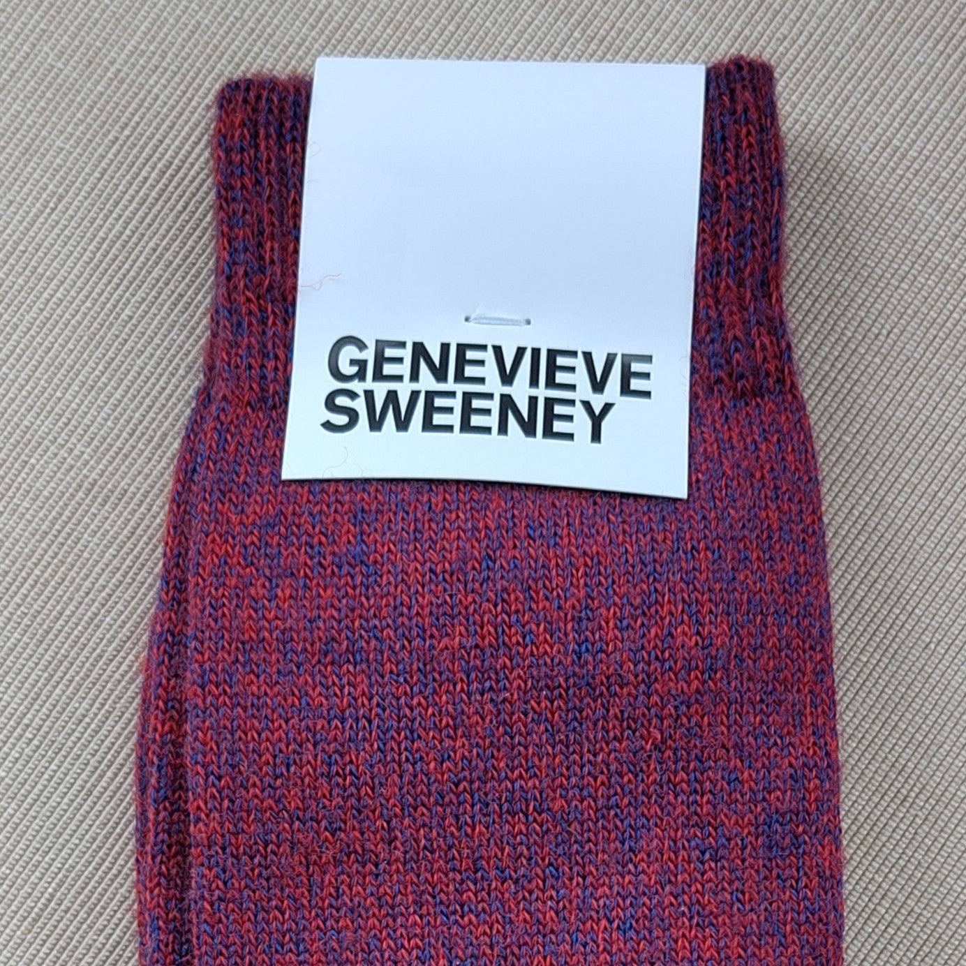 A close up image of socks and label showing the socks are a mix of red and blue yarns