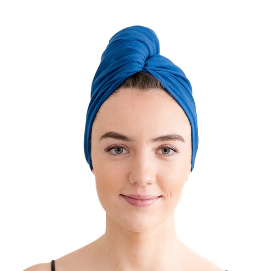 Woman wearing a blue hair towel wrapped around her head to resemble a turban