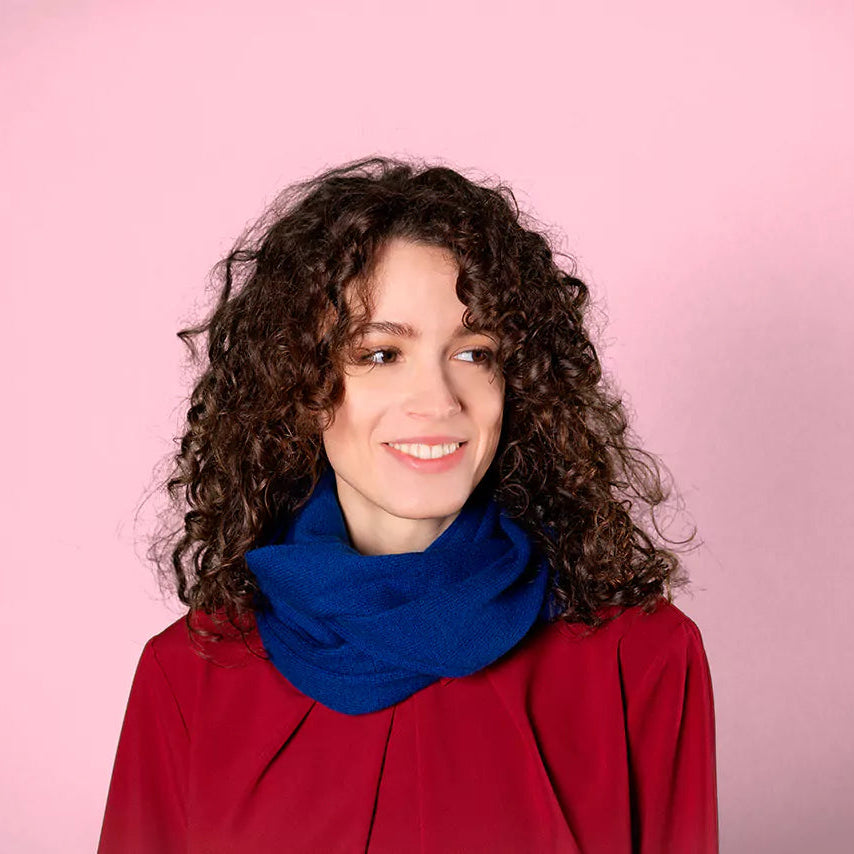 Woman wearing a bright blue loop scarf or snood around her neck