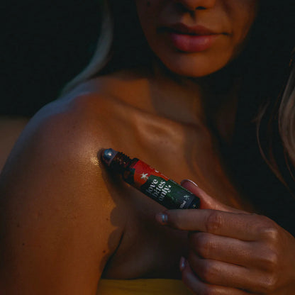 Person applying Love Bites Only insect repellent to their shoulder with a rollerball applicator