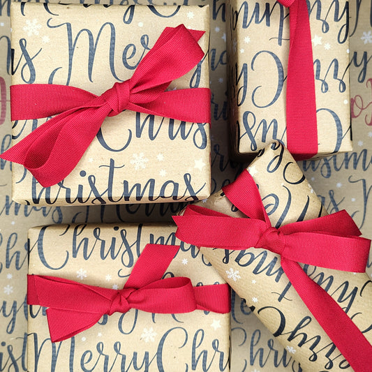 Presents wrapped in paper saying 'Merry Christmas' on it with red ribbon