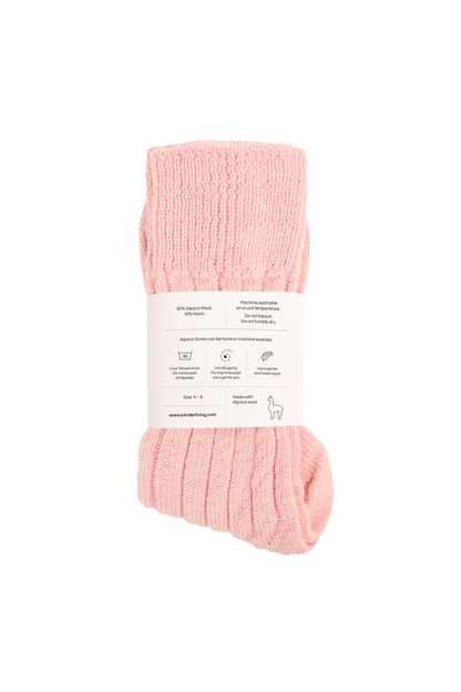 Pink socks with a label on a white background showing care instructions