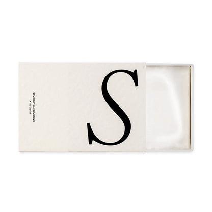 Rectangular white cardboard box with a large 'S' on it, open to show a folded white silk pillowcase inside