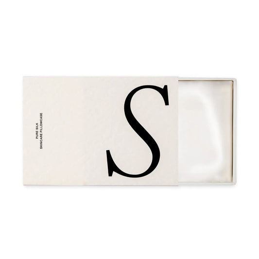 Rectangular white cardboard box with a large 'S' on it, open to show a folded white silk pillowcase inside