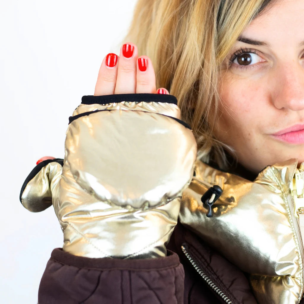 A woman holding her hand up showing the top of the glove folded down to show the tops of 4 fingers