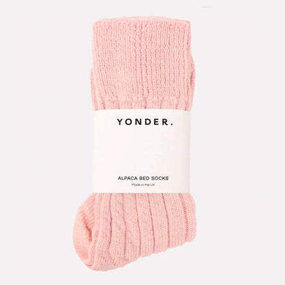 Pink bed socks with 'Yonder' label on a white background